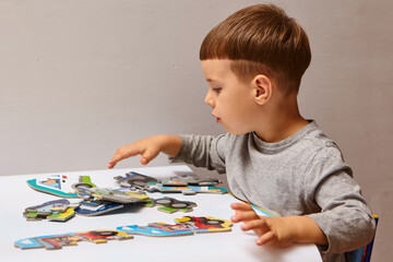 Child playing with puzzles,. The boy is playing in his room. Educational logic toys for kid's..
