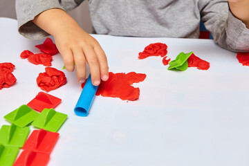 The boy is playing in his room. Young child playing with play doh or play dough. Educational toys for kid's. Games for Child Development.Child's hands kneading modelling clay.