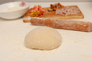 Fototapeta na wymiar Preparation of the dough for pizza. Hands prepare the dough