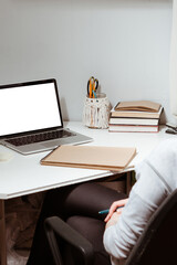 a young woman works at a computer at home. The concept of distance learning or work