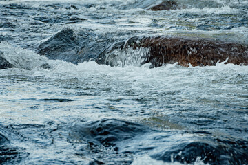 Stormy stream among rocks and boulders. Mountain river.