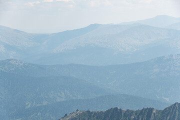 View of calming mountain valley with ridge on horizon. Gentle hills in blue haze.