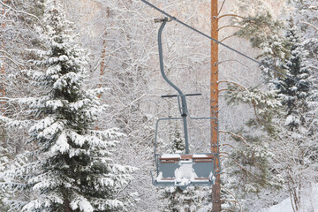 Chair lift in snowy winter landscap. Chairlift over frost forest