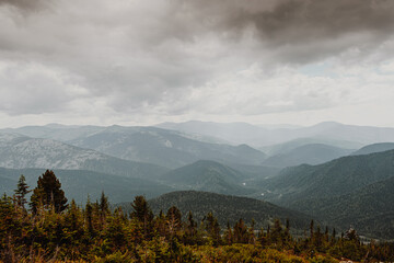 Scenic view of misty mountain valley. Gentle hills under overcast clouds.