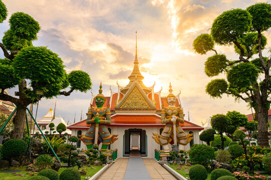 Wat Arun in the evening, the sunset, the giant Phithak Ravana and the two Sahasadecha stand beside the entrance.
