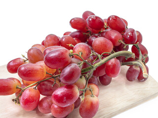 The close up of fresh red grapes organic fruit food on wooden board isolated on white background.