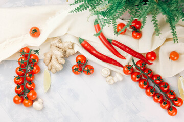 the composition of cherry tomatoes, peppers, mushrooms, lemon, ginger root is arranged on a light fabric and blue-white background . for restaurant menus, advertising. Flat lay. Top view. copy space 
