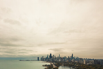 Beautiful aerial skyline view of the City of Chicago from the north side along the shoreline of Lake Michigan with Lake Shore drive and Diversey Harbor below and cloudy sky above with copy space.