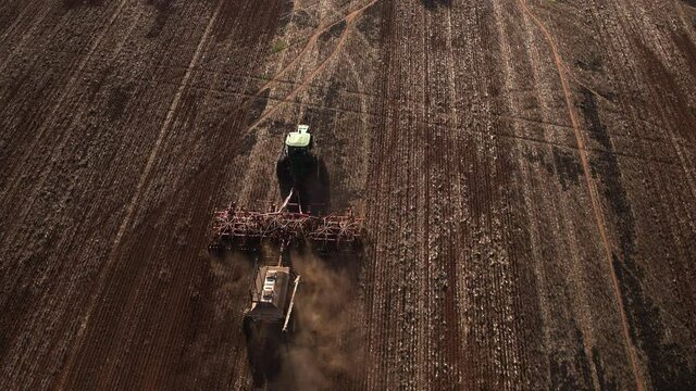 Aerial top down view of Agricultural Machinery tractor towing wheat seed drill sowing seed for crop in a large field in the rural city of Wagga Wagga NSW Australia
