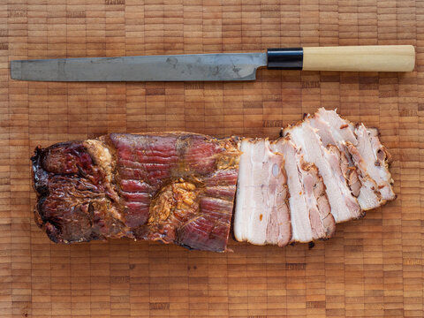 Chashu - aufgeschnitten f&uuml;r Ramen mit Messer auf Holzbrett