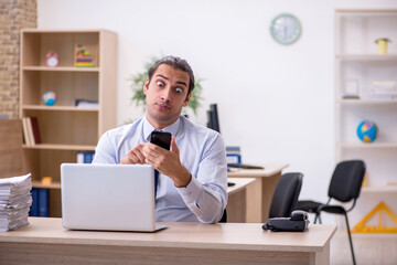 Young male employee sitting in the office