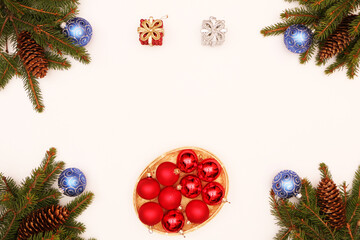  Fir branches with cones lie on a wooden background decorated with Christmas cookies and Christmas balls.