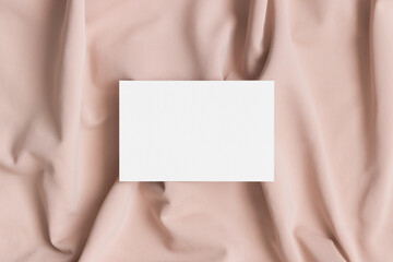 White business card mockup on a beige textile. 85x55mm