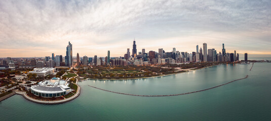 Wide angle Chicago city skyline aerial panorama with Lake Michigan in the foreground overlooking Grant Park and highrise skyscraper buildings with a beautiful orange and blue sunset sky above.