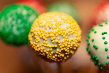 candy on a wooden stick with colorful sprinkles