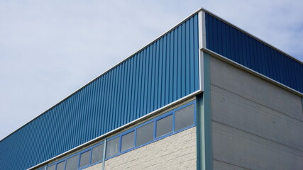 industrial warehouse building roof against sky background