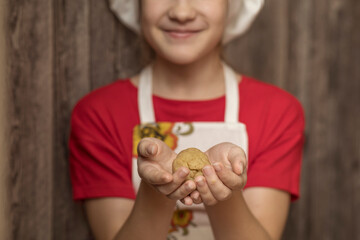 Little chef holds gingerbread dough in his hand. Homemade baking.