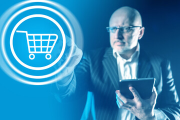 Businessman pressing button with a shopping cart. Online commerce symbol on a virtual screen....