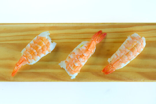 shrimp sushi nigiri on wooden board and white background