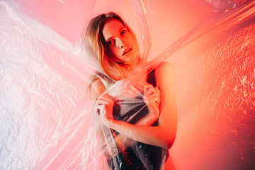 Neon light portrait. Female abuse. Gender equality. Self isolation. Worried insecure woman in black...