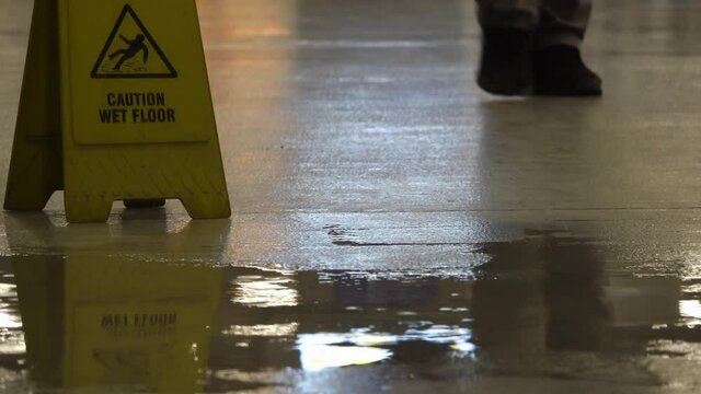 Yellow warning sign on the wet floor. Sign showing warning of caution rainy evening wet floor.