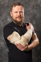 Matured man with bandaged hand studio portrait.