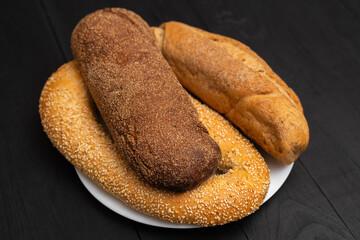 Different types of bread on a black background.