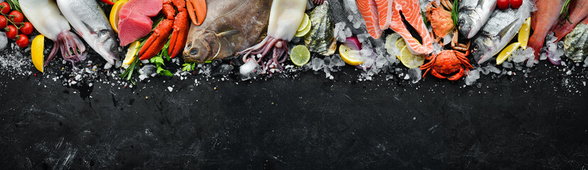 Seafood. Set of fish, crustaceans, oysters, mussels and seafood on a black stone background. Free...