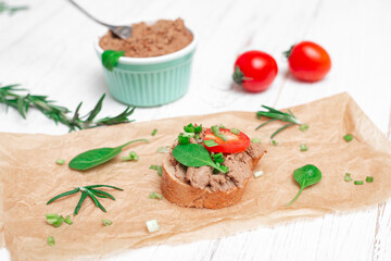 Sandwiches, canapes with chicken pate, tomatoes. On a white wooden background.