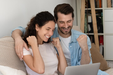 Close up overjoyed family looking at laptop screen, celebrating success, smiling young man and woman showing yes gesture, excited by good news, shopping sales offer, approved loan or mortgage