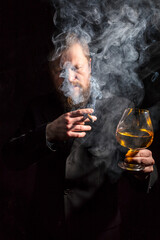 Solid confident bearded man in suit with glass of whisky and cigar with fume