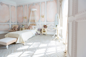Luxurious expensive interior design of the children's room in the old Baroque style in beige colors