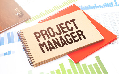 Notepad with text PROJECT MANAGER. Diagram, red notepad and white background
