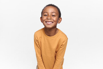 Positive emotions, joy and happy childhood. Adorable black boy posing against blank white copy...