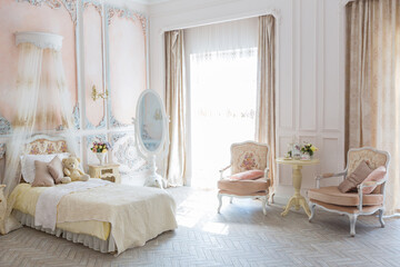 Luxurious expensive interior design of the children's room in the old Baroque style in beige colors