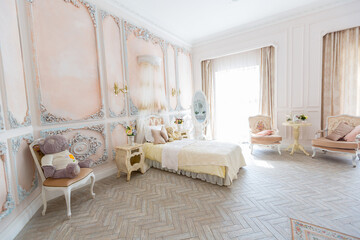 Luxurious expensive interior design of the children's room in the old Baroque style in beige colors