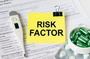 A yellow sticker with the text Risk Factor is on the health insurance form with pills and an...