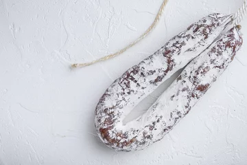 Selbstklebende Fototapeten Salami sausage fuet on white textured background © Ilia Nesolenyi