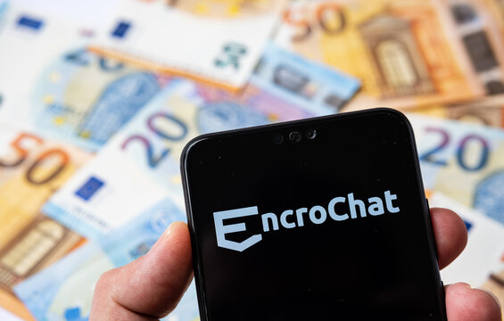 Stone / UK - July 5 2020: EncroChat Logo On The Smartphone And Spread Pile Of Euros. Selective Focus.