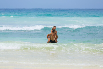 Happy lover couple have fun, in the Indian Ocean together spending their honeymoon.