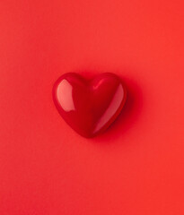 Valentine's day or Wedding romantic concept. Red heart on red background. Top view, copy space.