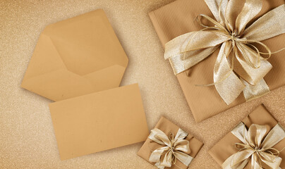 greeting gift card, top view of wrapped packages of champagne color with golden ribbon bow, envelope and ticket, isolated on beige background