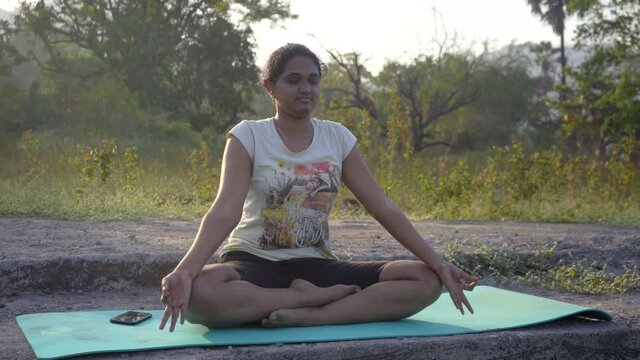 Dorothy doing yoga seating praying in backlight sunlight sunrise sunset  India Mumbai thane lakeside