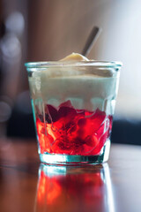 Cranberry jelly dessert with whipped cream in a glass