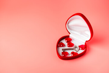 Key in a box of heart shape as a symbol of love. Valentines day background. Greeting card with red heart on pink background