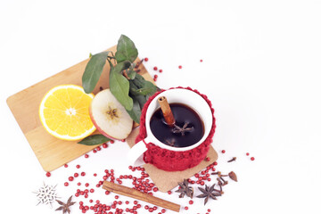 Delicious mulled wine and ingrediets on white background.Hot red beverage in cozy mug with christmas spices, anise, orange and apple slice, cinnamon sticks.Holiday christmas hygge and homely concept