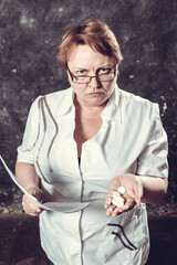 Middle aged woman pharmacist in medical robe offers the tablets