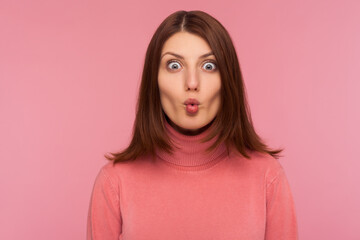 Closeup portrait attractive brunette woman in pink sweater fooling around making fish lips, having fun, humor. Indoor studio shot isolated on pink background