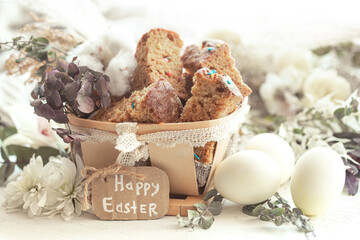 Happy Easter composition with pieces of Easter cake in a decorative basket and eggs.