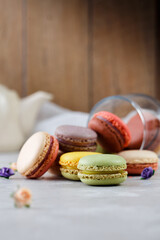 Colorful macarons on white table and wooden background